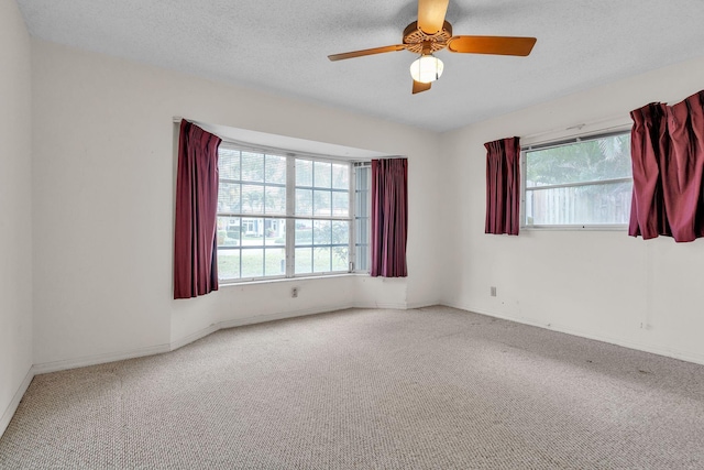 carpeted spare room with a textured ceiling and ceiling fan