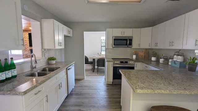 kitchen with sink, white cabinetry, stainless steel appliances, and dark wood-type flooring