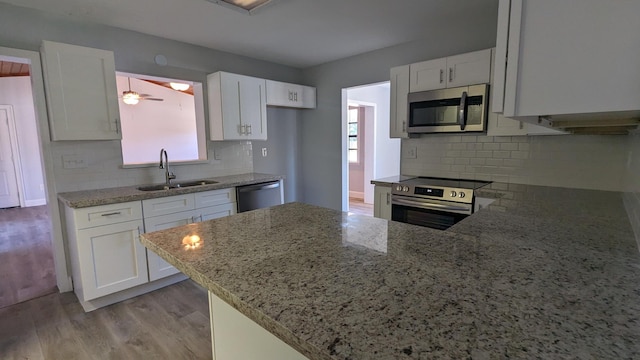 kitchen with sink, white cabinets, stainless steel appliances, and light hardwood / wood-style floors