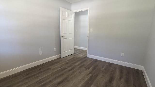 empty room with dark hardwood / wood-style flooring