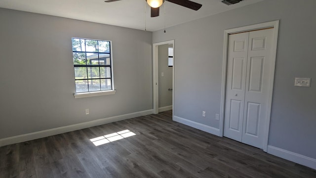 unfurnished bedroom featuring dark hardwood / wood-style floors, ceiling fan, and a closet