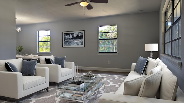 living room featuring wood-type flooring and ceiling fan with notable chandelier