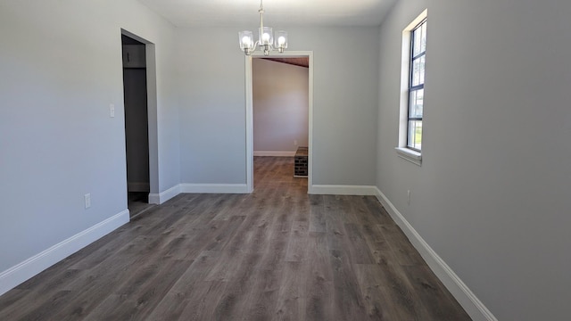 unfurnished room with dark hardwood / wood-style flooring and a chandelier