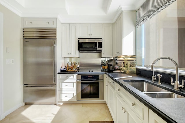 kitchen with sink, white cabinets, light tile patterned floors, and appliances with stainless steel finishes