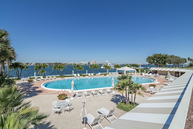 view of swimming pool with a water view and a patio