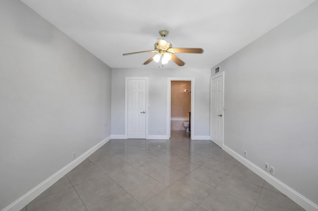 spare room with ceiling fan and light tile patterned floors