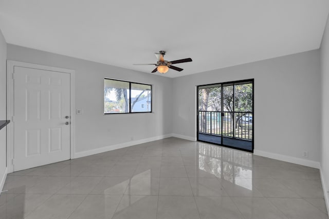 tiled spare room featuring ceiling fan