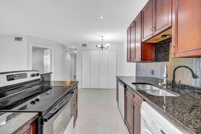 kitchen with stainless steel appliances, decorative light fixtures, a notable chandelier, washer / dryer, and light tile patterned flooring