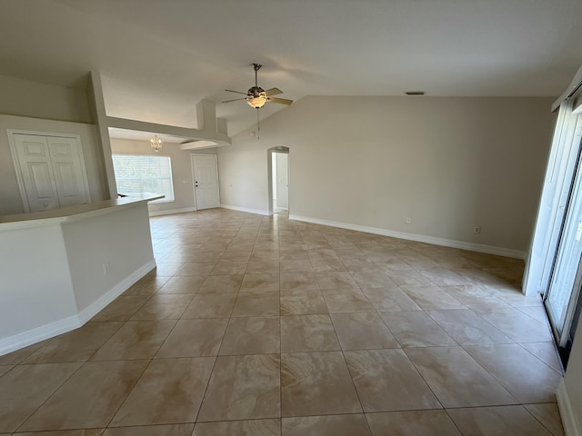 unfurnished living room featuring vaulted ceiling, light tile patterned flooring, and ceiling fan with notable chandelier