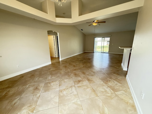 unfurnished room featuring a towering ceiling, light tile patterned floors, and ceiling fan