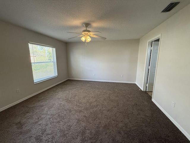 carpeted empty room with ceiling fan and a textured ceiling