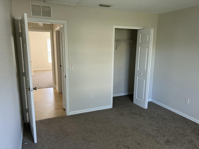 unfurnished bedroom with a closet and dark colored carpet