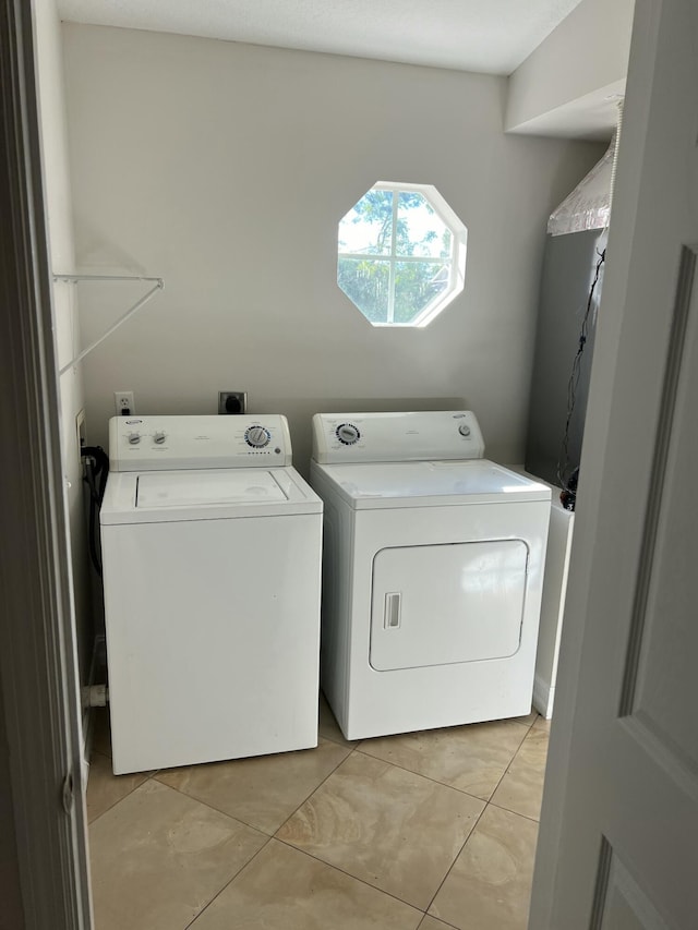 laundry room featuring washer and dryer and light tile patterned floors