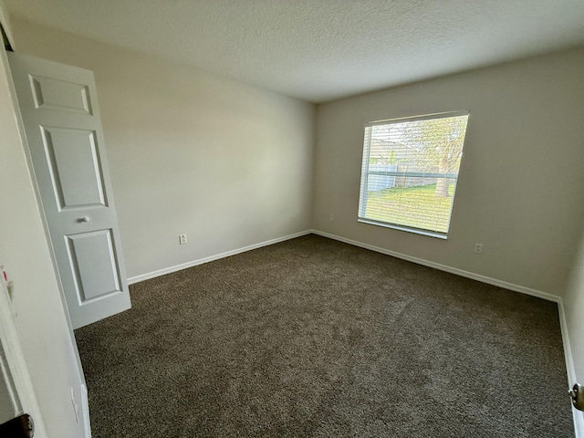 carpeted empty room with a textured ceiling