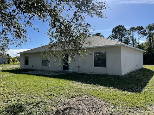 back of house with a lawn and a patio area