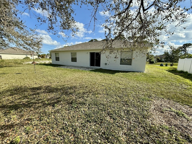 back of house with a lawn