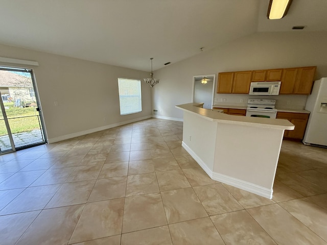 kitchen with pendant lighting, white appliances, a center island, and light tile patterned flooring