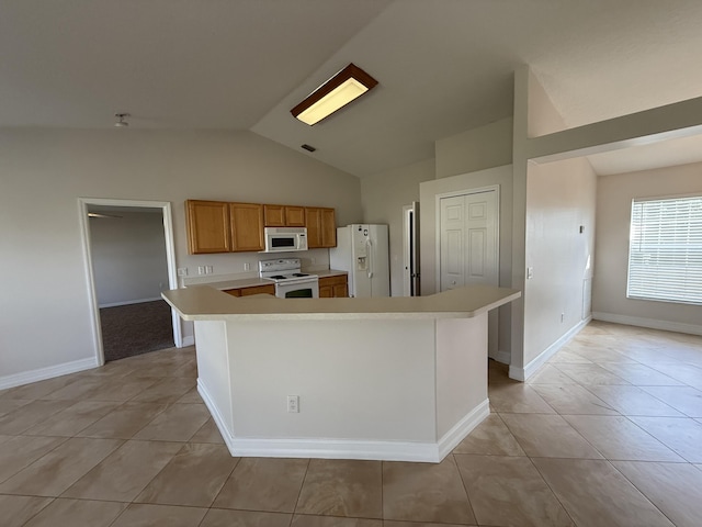 kitchen featuring white appliances, vaulted ceiling, a center island, and light tile patterned flooring