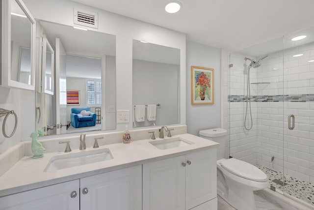 bathroom with vanity, toilet, and a shower with door