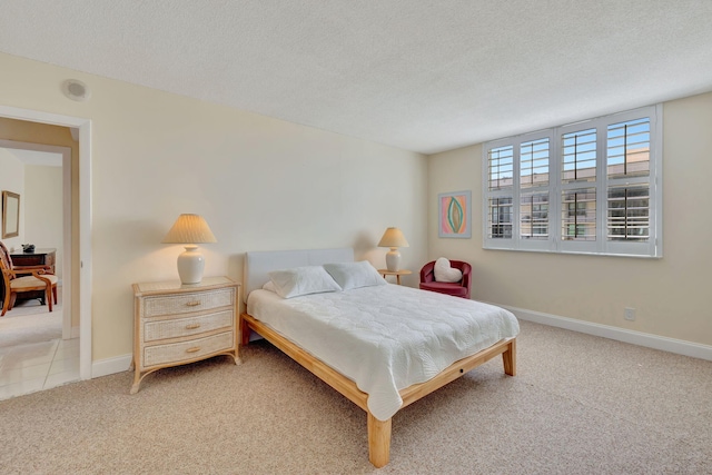 bedroom with light colored carpet and a textured ceiling