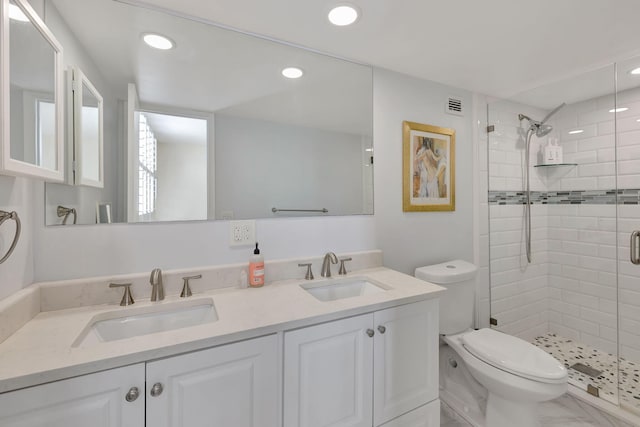 bathroom with vanity, a shower with shower door, and toilet