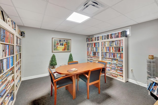 dining area featuring a paneled ceiling and carpet flooring