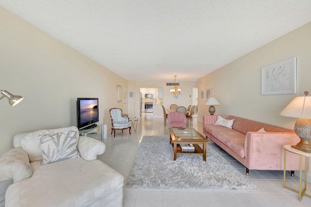 living room featuring light tile patterned flooring, a chandelier, and a textured ceiling