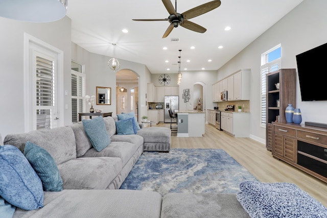 living room with ceiling fan, sink, and light hardwood / wood-style floors