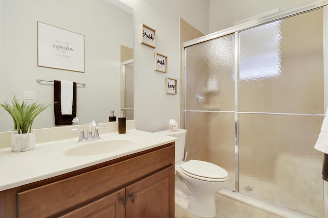 bathroom with tile patterned flooring, vanity, toilet, and a shower with door