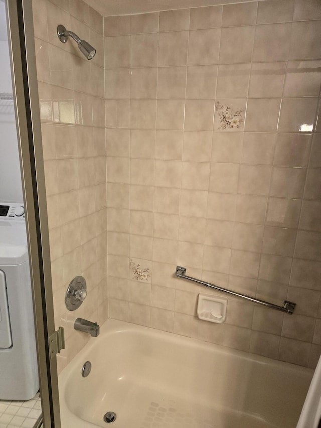 bathroom with tiled shower / bath combo and washer / dryer