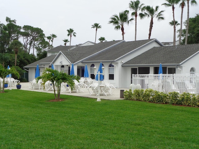 rear view of house with a patio area and a lawn