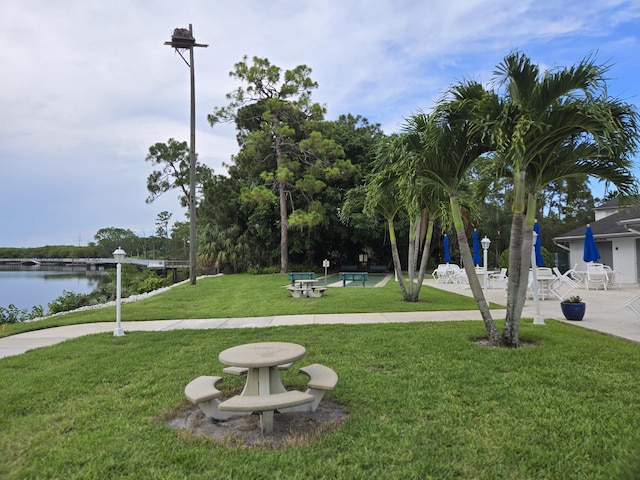 view of home's community featuring a water view and a lawn