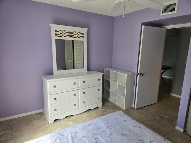 unfurnished bedroom featuring ceiling fan, light tile patterned floors, and a textured ceiling