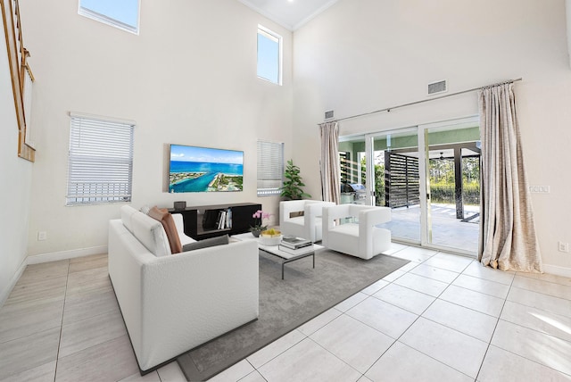 living room with plenty of natural light, light tile patterned floors, and a towering ceiling