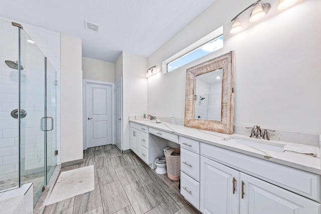 bathroom with a shower with door and vanity