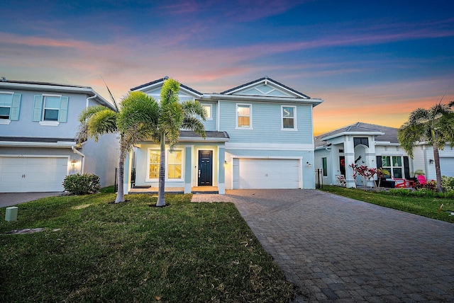 view of front of home with a yard and a garage