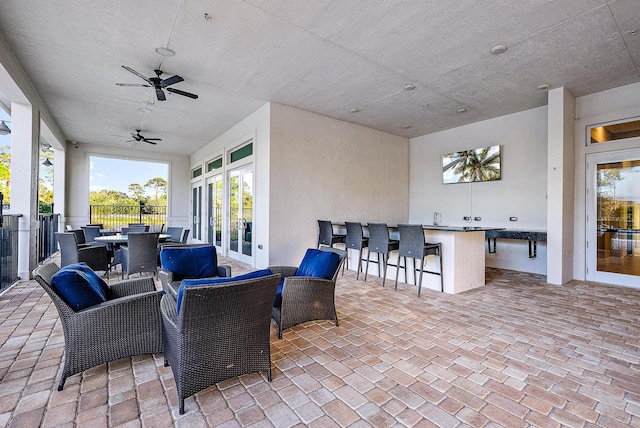 view of patio featuring ceiling fan and exterior bar