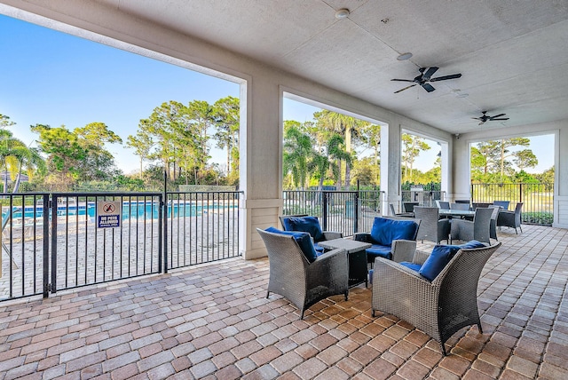 view of patio featuring ceiling fan, a community pool, and an outdoor living space