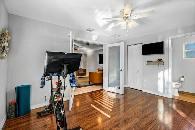 exercise room featuring ceiling fan, french doors, and hardwood / wood-style flooring