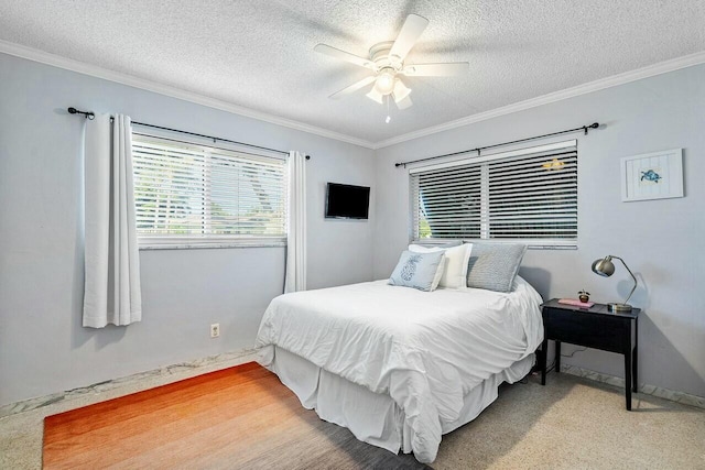 bedroom featuring ceiling fan, a textured ceiling, and ornamental molding