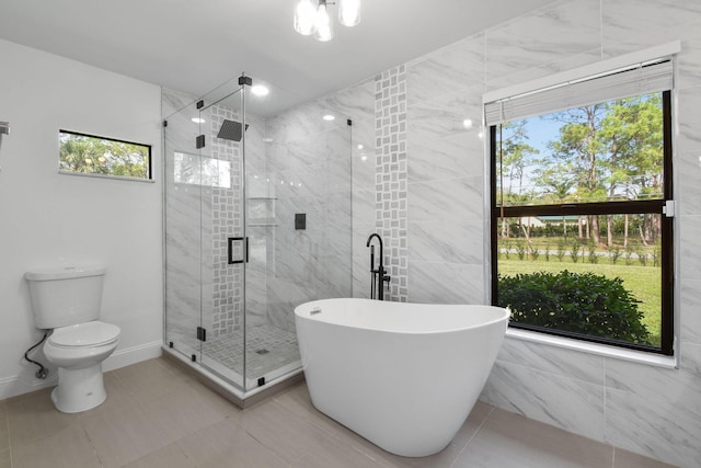 bathroom with a wealth of natural light, tile patterned floors, plus walk in shower, and toilet