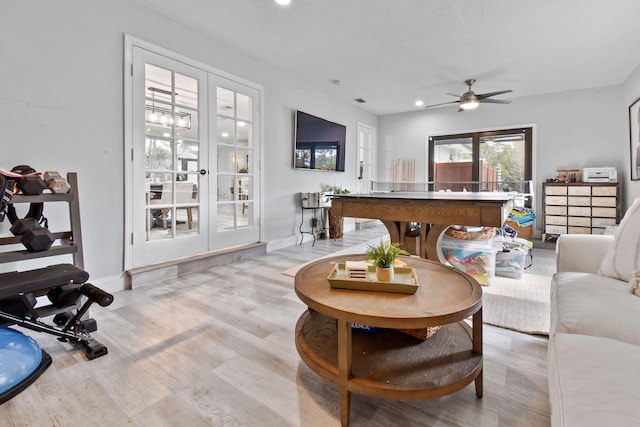 living room with french doors, ceiling fan, and light wood-type flooring