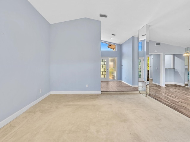 unfurnished living room featuring carpet floors and high vaulted ceiling