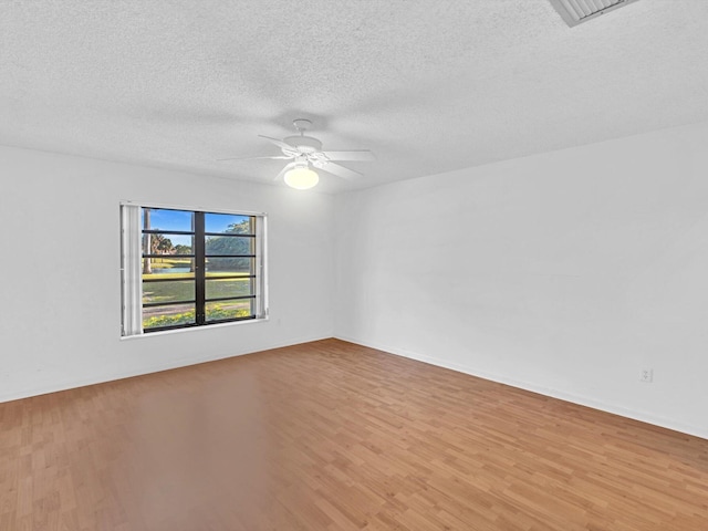 spare room with a textured ceiling, light hardwood / wood-style floors, and ceiling fan