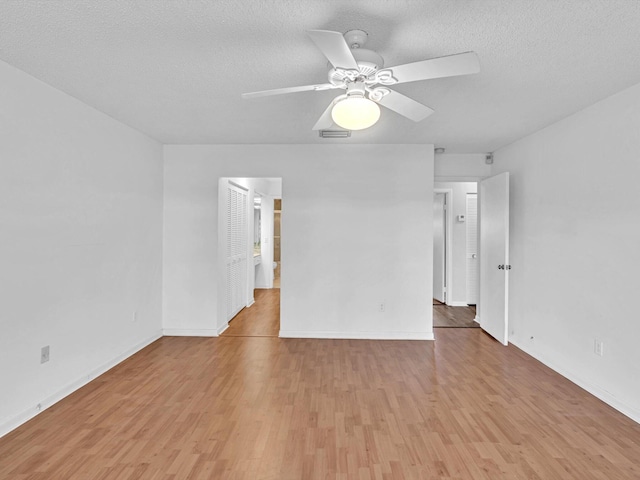 unfurnished room with ceiling fan, light hardwood / wood-style floors, and a textured ceiling