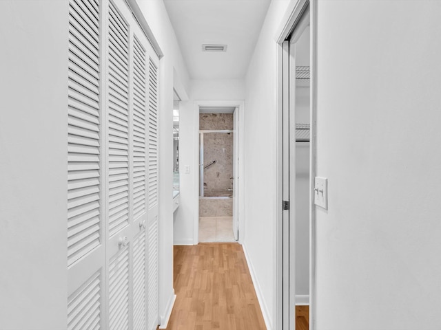 hallway with light hardwood / wood-style floors