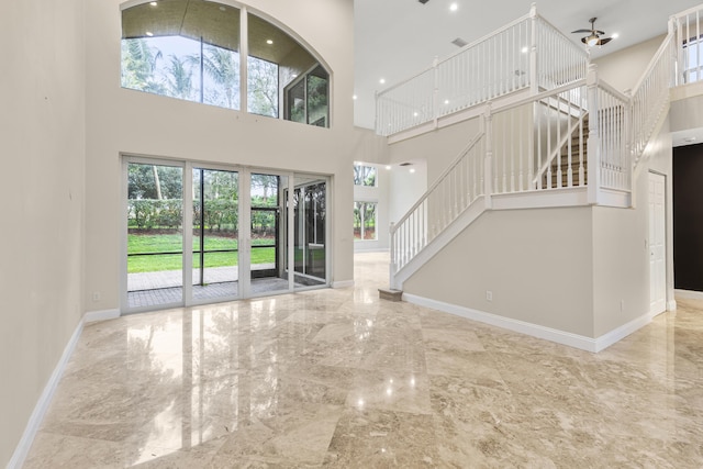 unfurnished living room featuring a towering ceiling