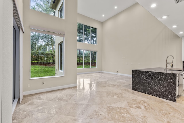 living room with sink and a towering ceiling