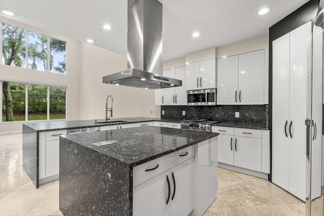 kitchen featuring sink, appliances with stainless steel finishes, white cabinetry, island range hood, and a kitchen island