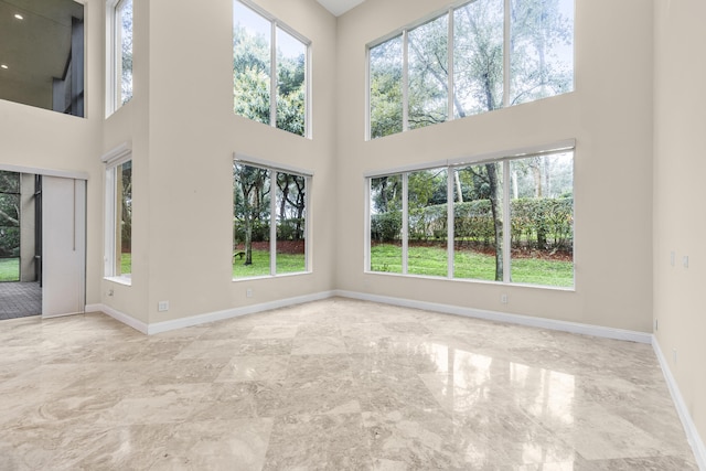 unfurnished living room featuring a high ceiling